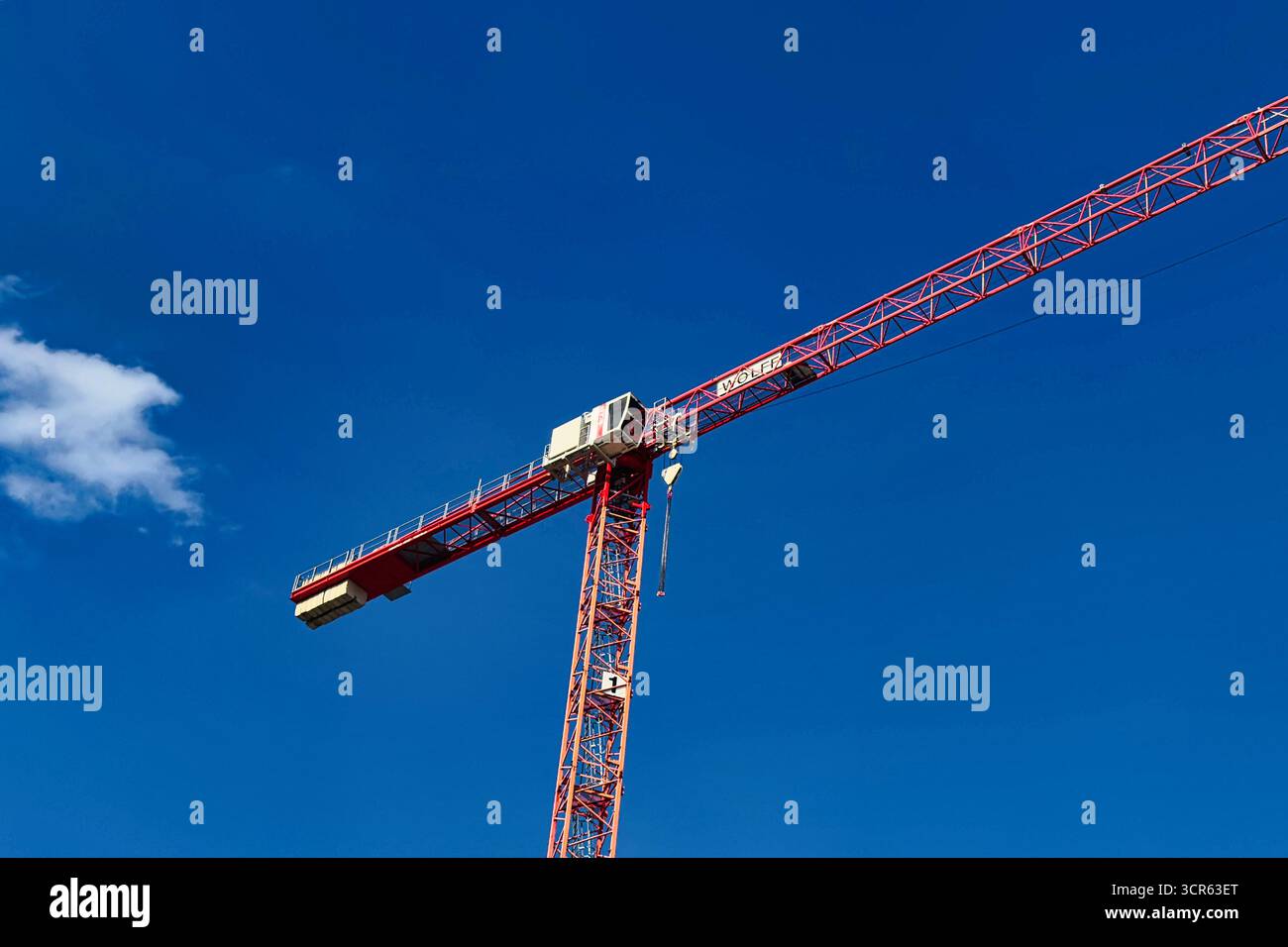 Red construction crane against blue sky, tower crane detail for building and industrial construction Stock Photo