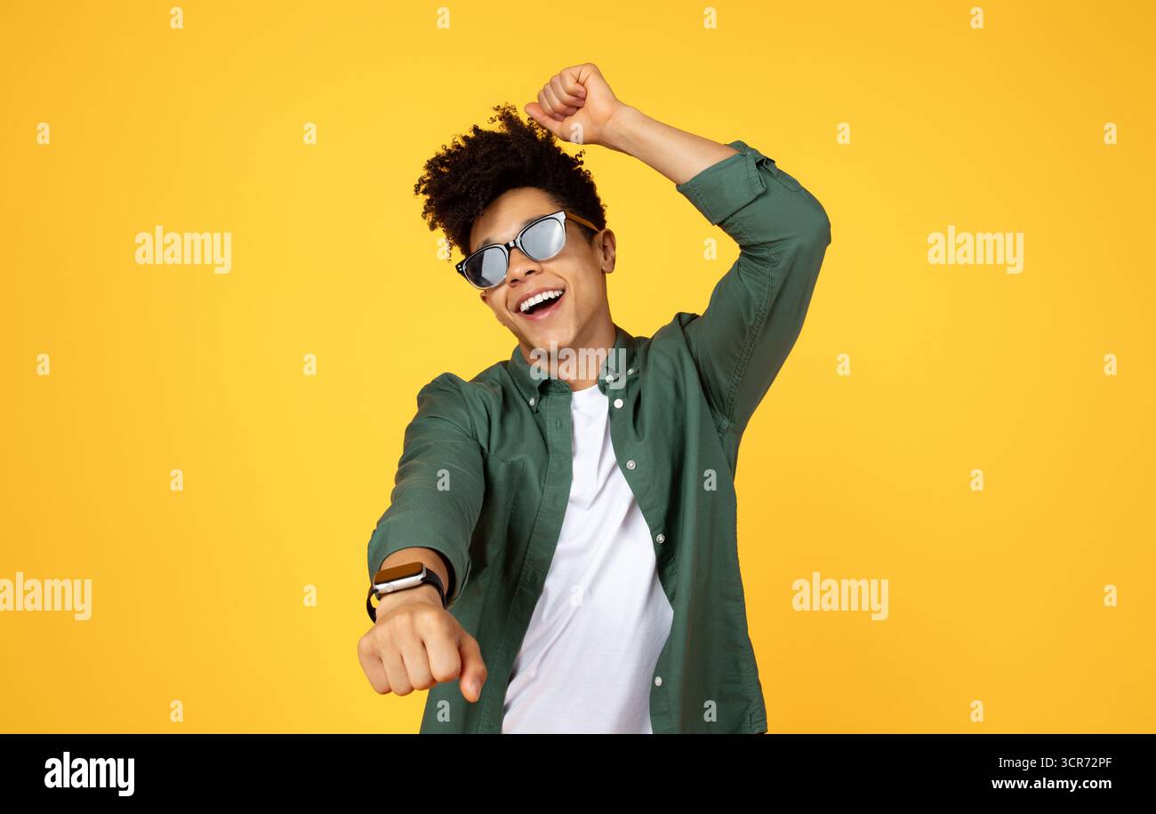 Carefree young black guy wearing sunglasses dancing Stock Photo
