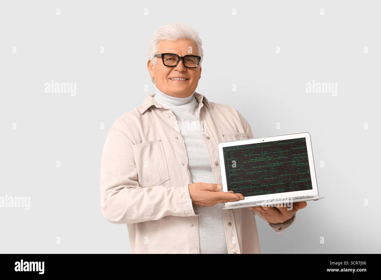 Senior programmer with laptop on light background Stock Photo