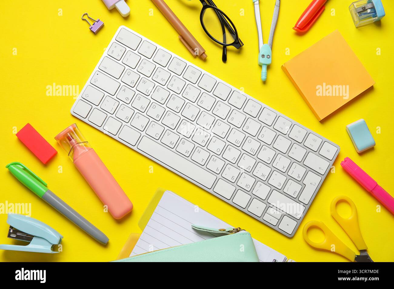 Composition with modern computer keyboard and different stationery on yellow background Stock Photo