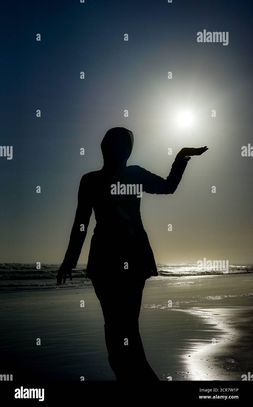 Silhouette of Woman Holding the Sun at Beach Sunset Stock Photo - Alamy