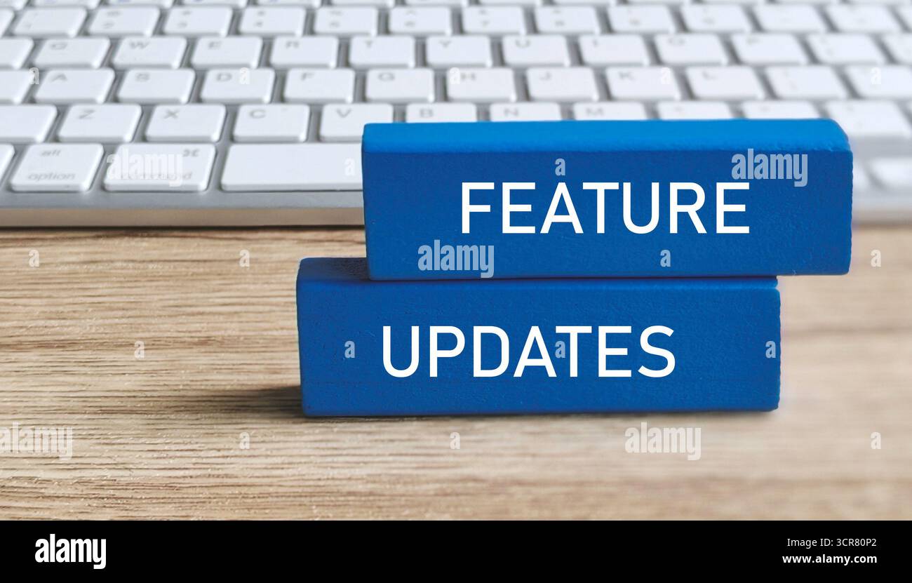 FEATURE UPDATES Text on Blue Blocks with Computer Keyboard Background for Software or Product Development Stock Photo