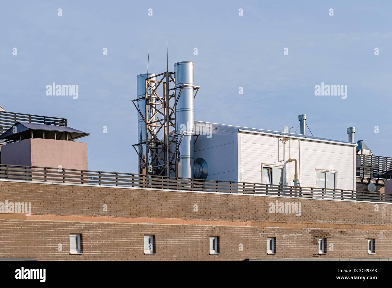 Rooftop autonomous gas boiler house with metal chimneys and pipes on ...