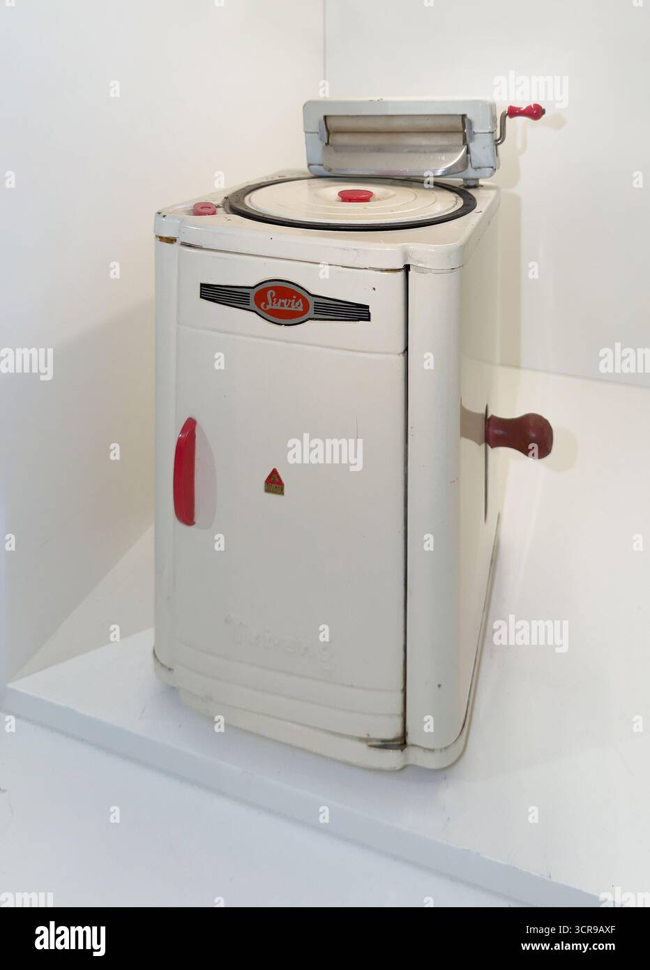 Vintage miniature Triang Servis washing machine model with classic design features and manual wringer, displayed in a bright, minimalist setting - Smartphone Captured Stock Image