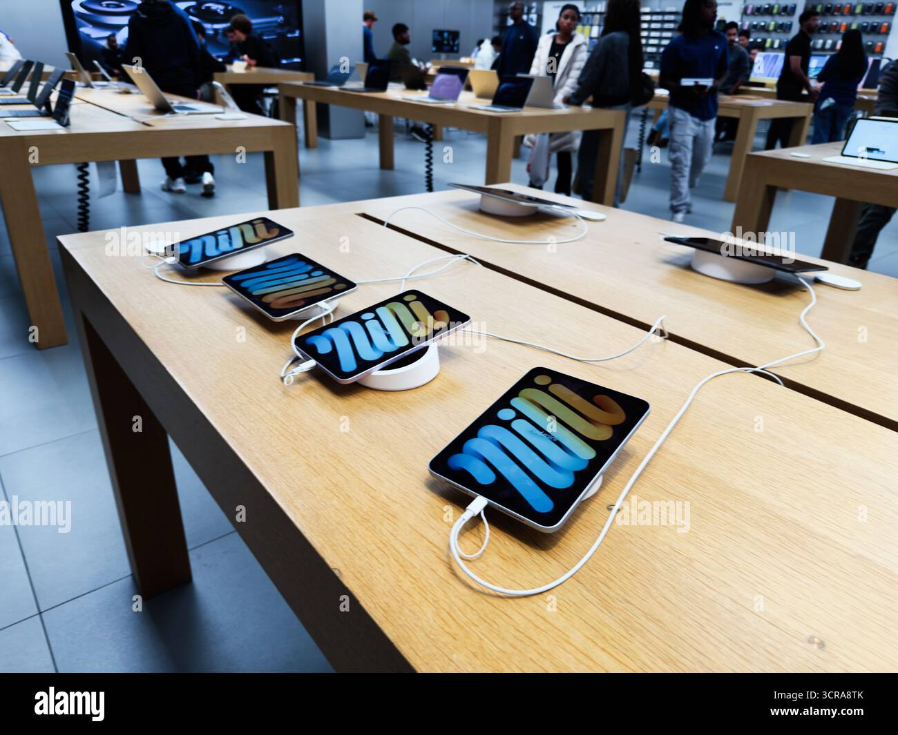Customers compare iPhones at an Apple retail store as the company tests a new segmentation framework in internal planning materials.