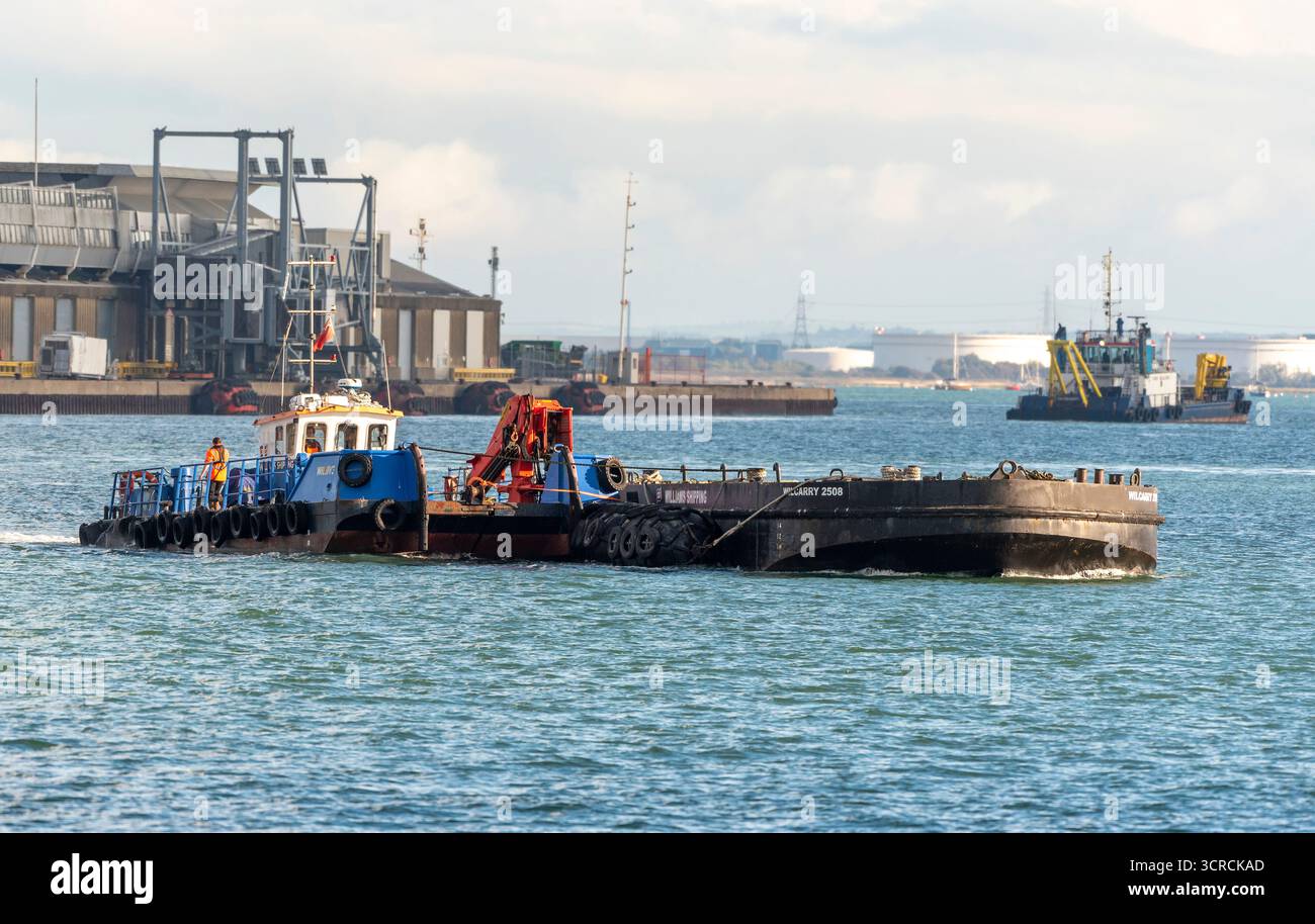 Southampton England UK. 27.09.2025.  Workboat Wiljive wirh a flat top pontoon crossing Southampton Water in southern England UK. Stock Photo