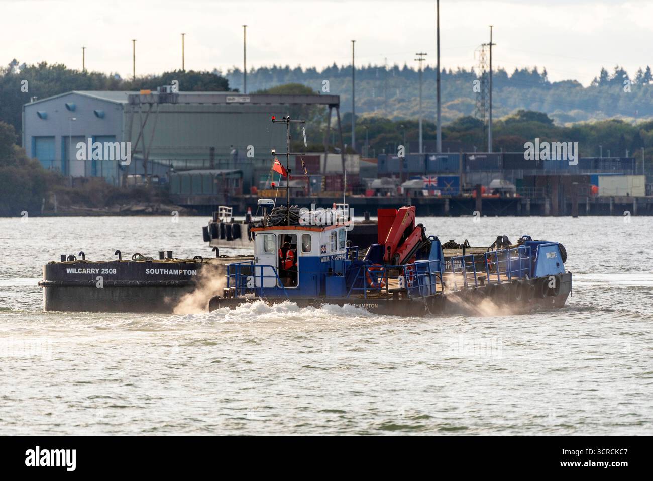 Southampton England UK. 27.09.2025.  Workboat Wiljive wirh a flat top pontoon crossing Southampton Water in southern England UK. Stock Photo