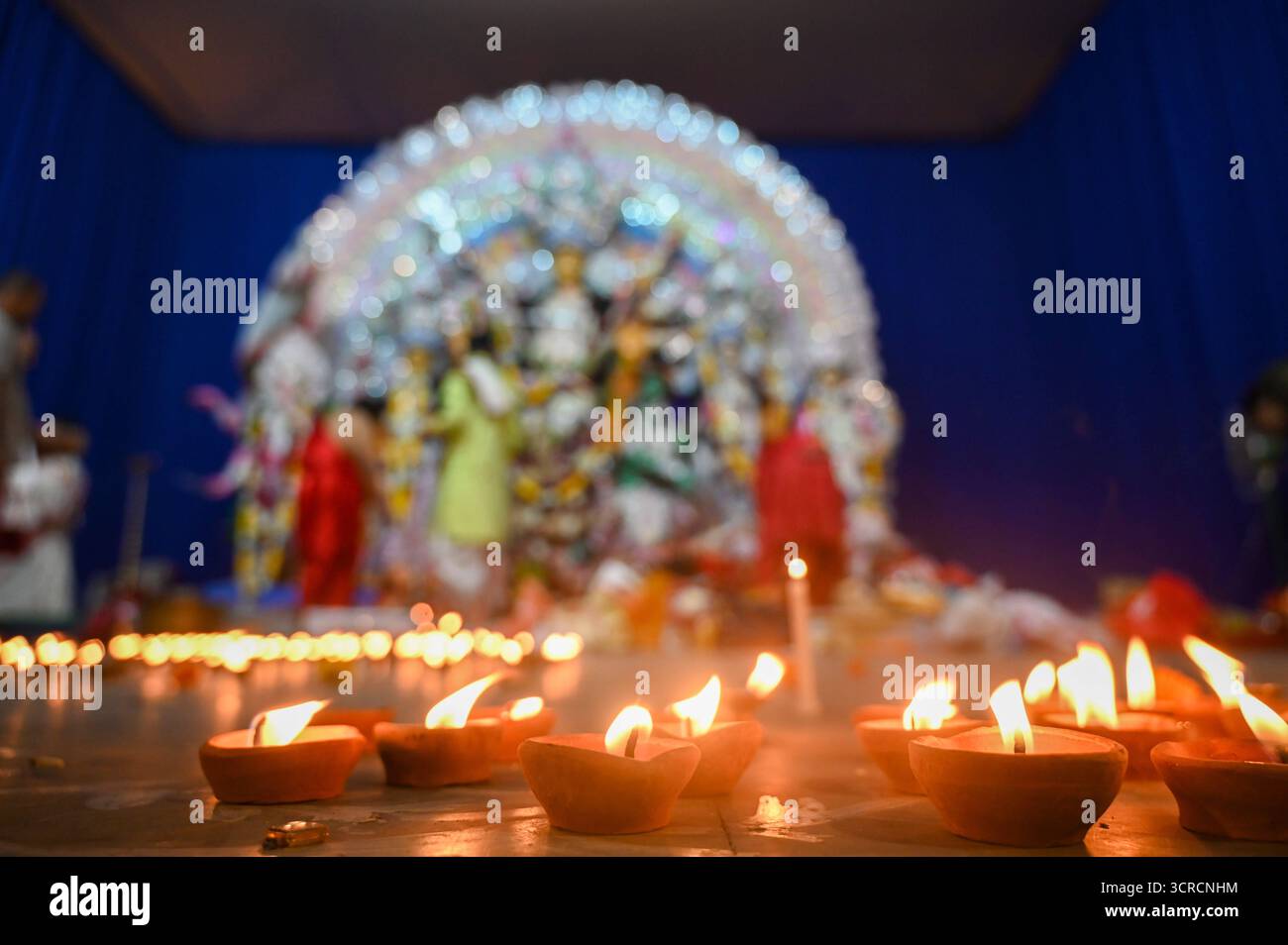 NOIDA, INDIA - SEPTEMBER 30: Devotees light earthen lamps Diyas while ...