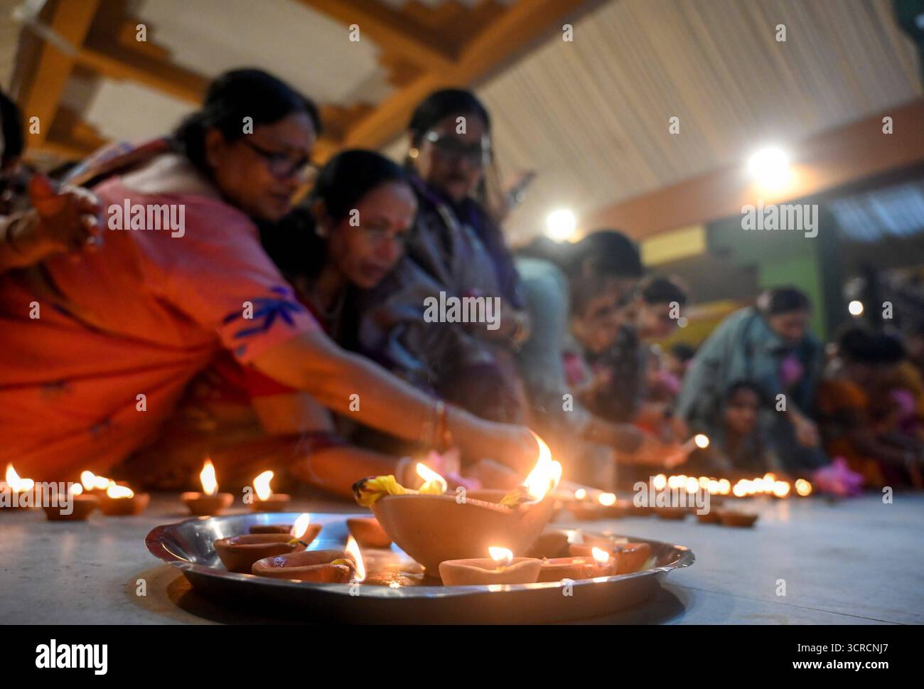 NOIDA, INDIA - SEPTEMBER 30: Devotees light earthen lamps Diyas while ...