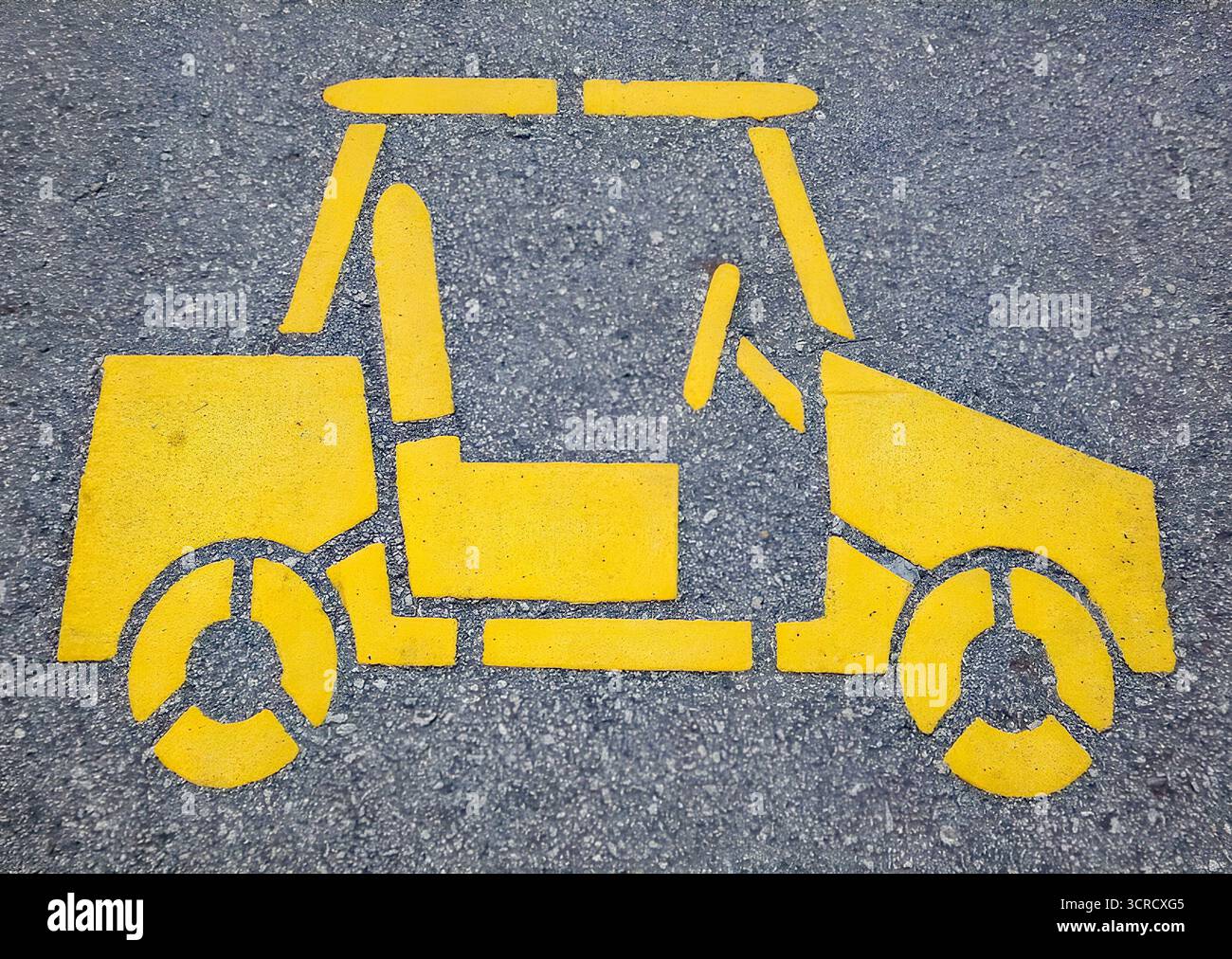 Yellow road marking of a compact car icon painted on asphalt, urban transport symbol. Stock Photo