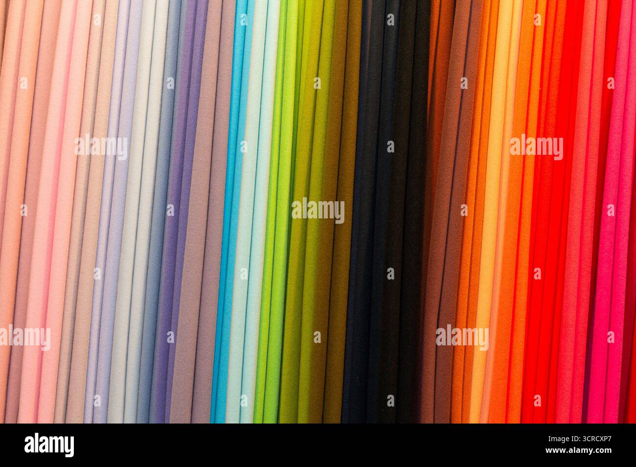 Multicolored textile material in a row on the store counter. Sale Stock Photo