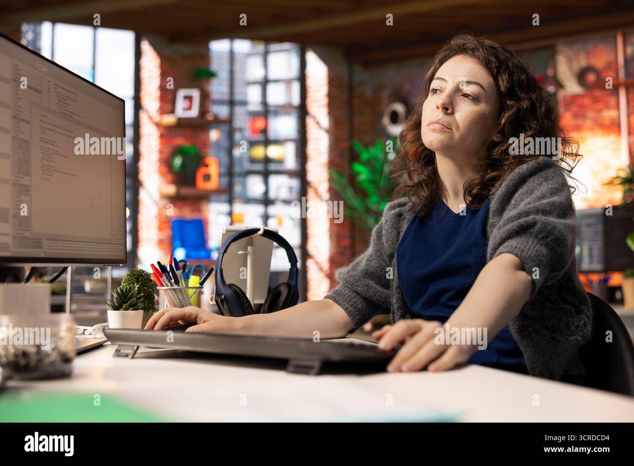 Female programmer developing an app and software algorithm on pc, working at the creative agency. Engineer uses digital tools and focuses on java script engineering and coding, IT specialist. Stock Photo