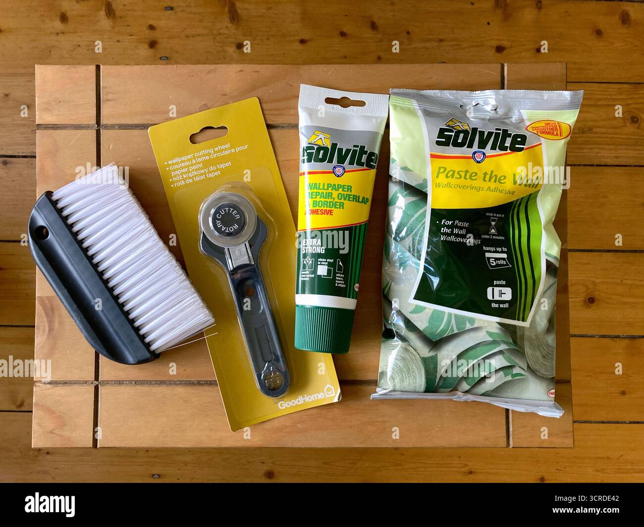 Preparation Items for wallpapering: wallpaper paste, wallpaper repair adhesive, wallpaper cutting tool and a wallpaper brush - Smartphone Captured Stock Image