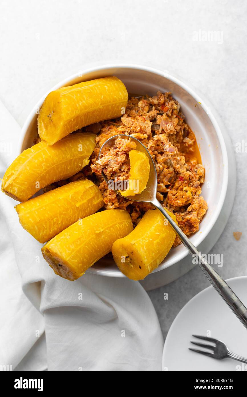 overhead view of Boiled ripe plantain with tomato scrambled eggs in a ...