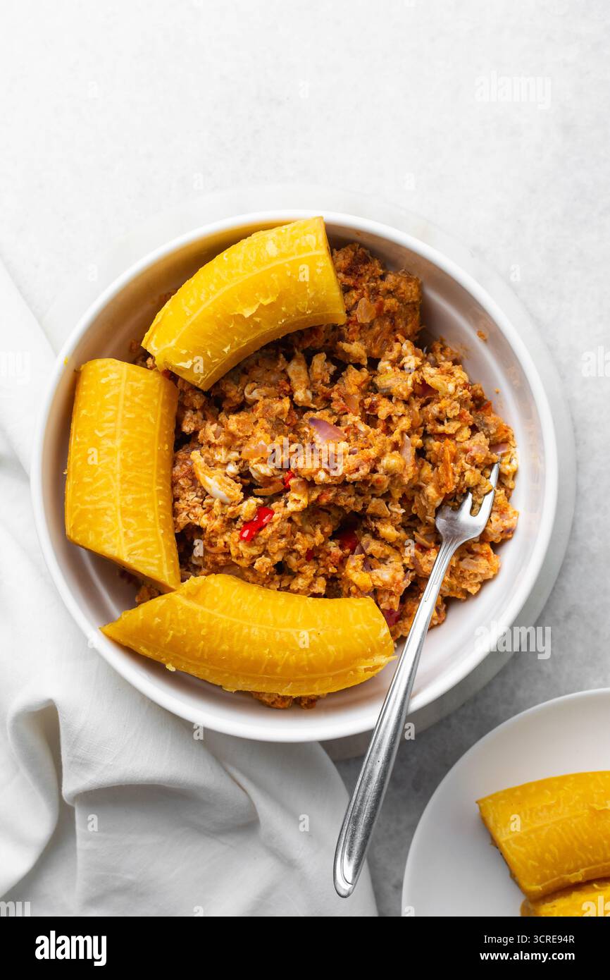 overhead view of Boiled ripe plantain with tomato scrambled eggs in a ...
