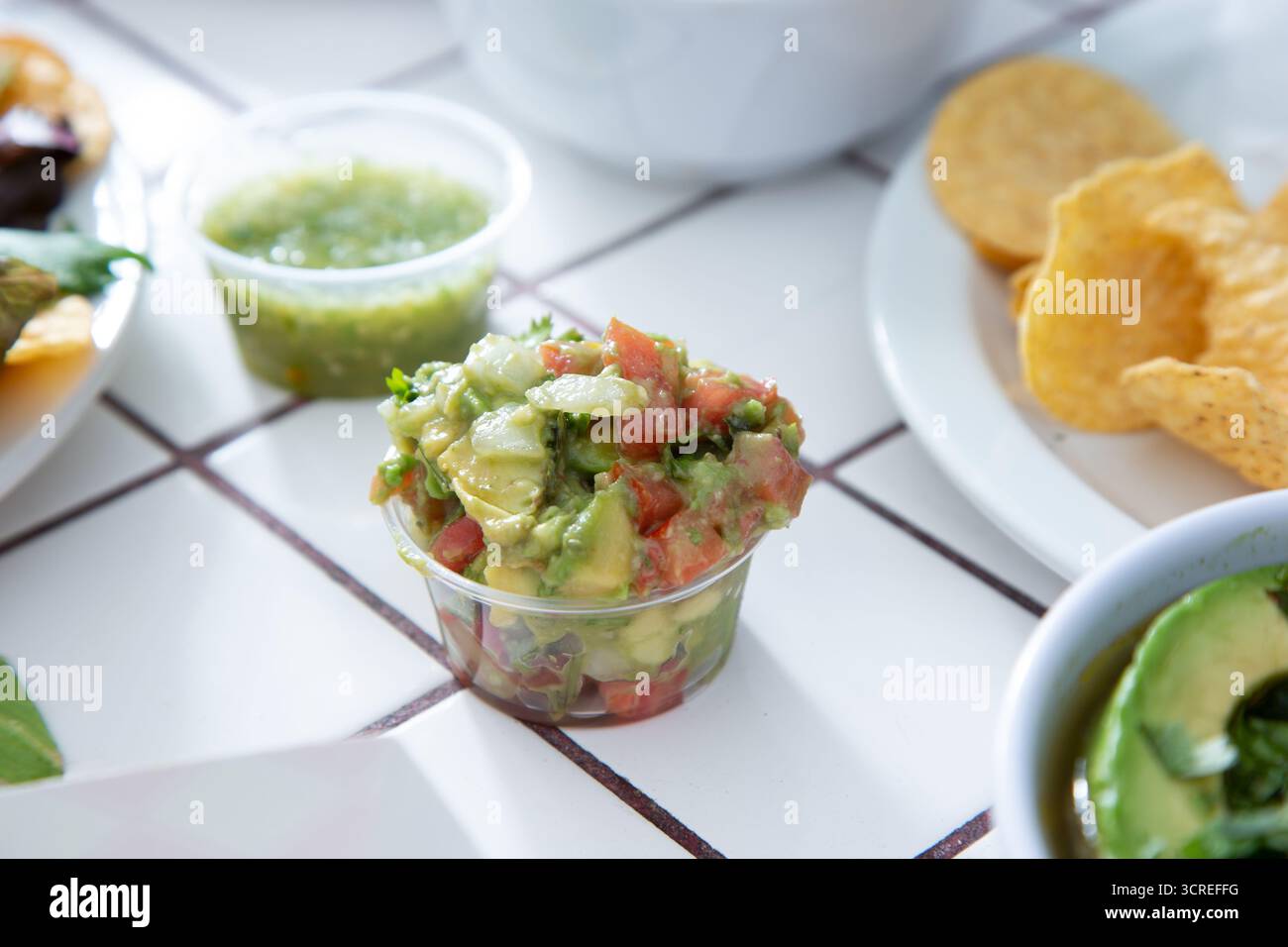 A view of a chunky guacamole salsa in a plastic condiment cup. Stock Photo