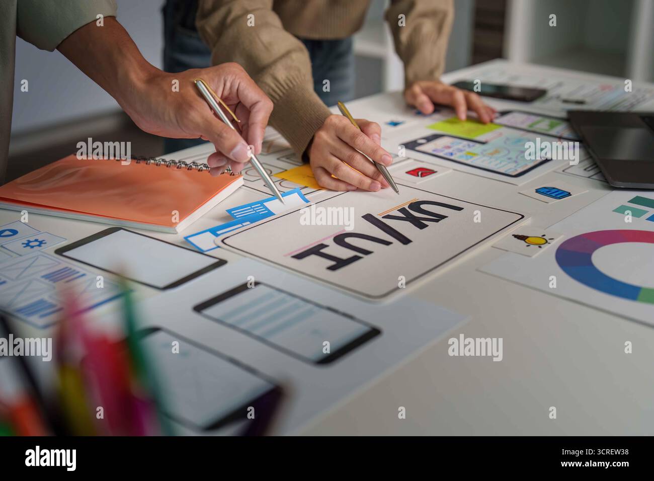 UX UI Design Collaboration. Creative team brainstorming on mobile app interface. Stock Photo