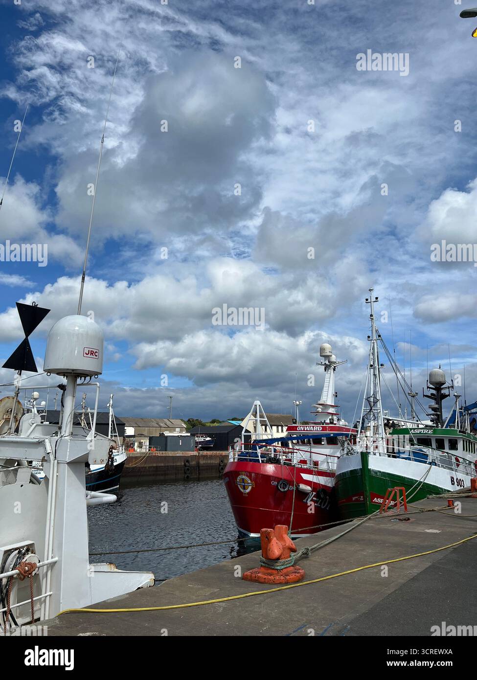 Colorful fishing boats docked at Killybegs Harbour, County Donegal, Ireland, on a cloudy day. - Smartphone Captured Stock Image
