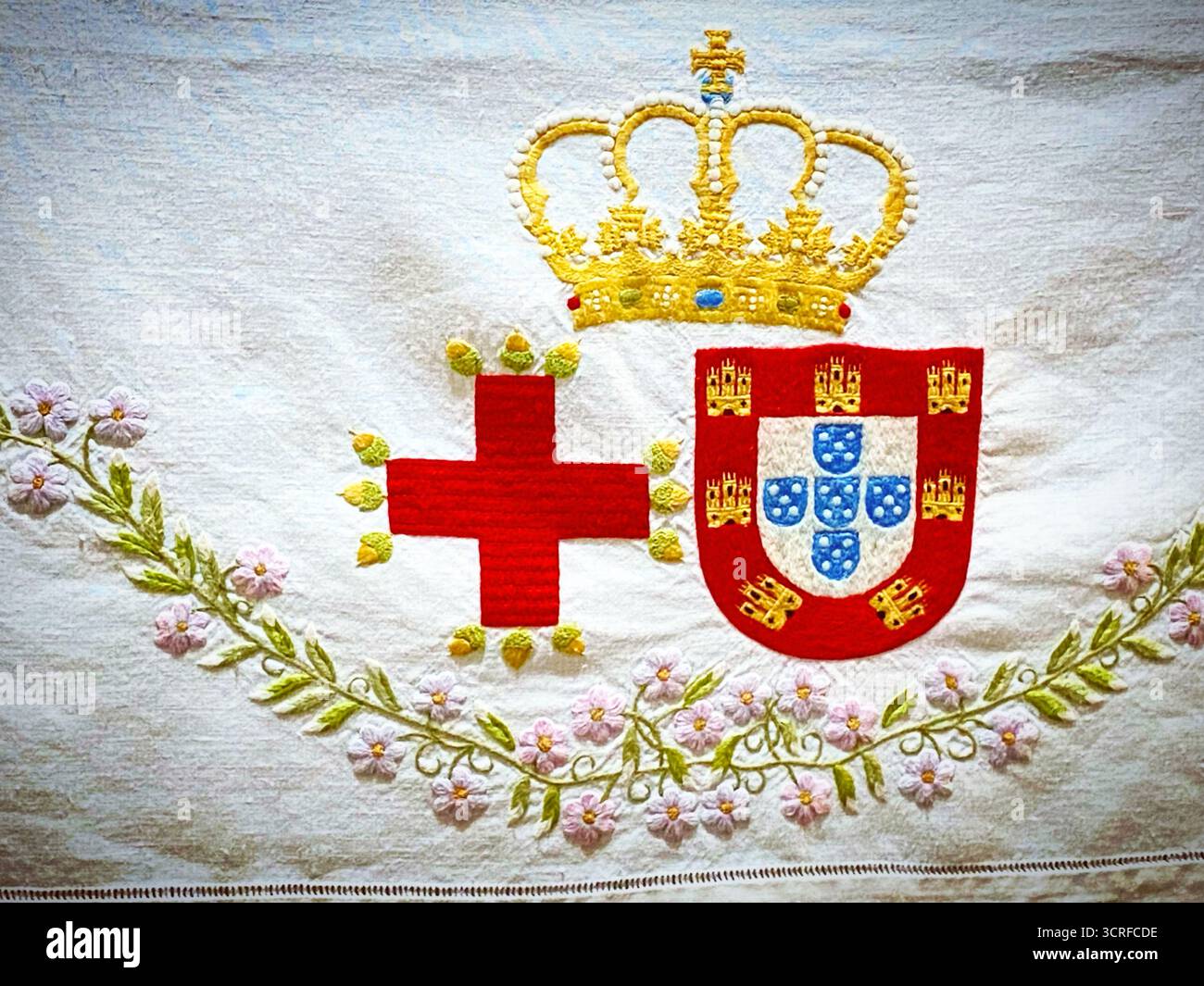 A embroidery with a kings crown, a red cross and de Lisbon shield decorates the natal house of Saint Anthony of Lisboa or Padua in Lisbon, Portugal. - Smartphone Captured Stock Image