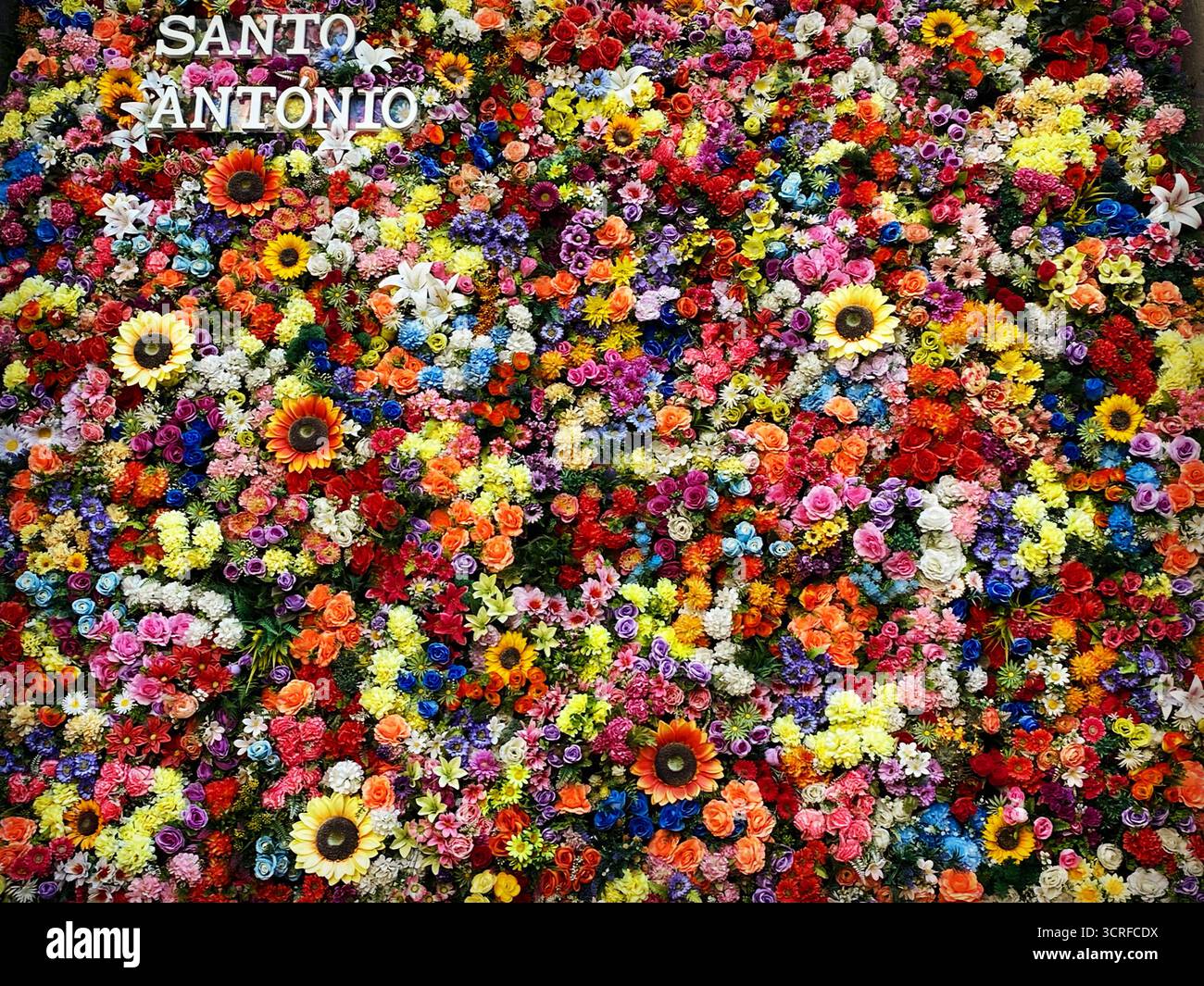 Flowers and a sign reading 'Santo Antonio' decorate a wall in the natal house of Saint Anthony of Lisboa os San Antonio de Padua, in Lisboa, Portugal. - Smartphone Captured Stock Image