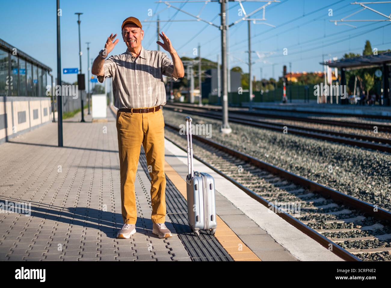 Angry senior man is standing at railway station. He is angry because ...