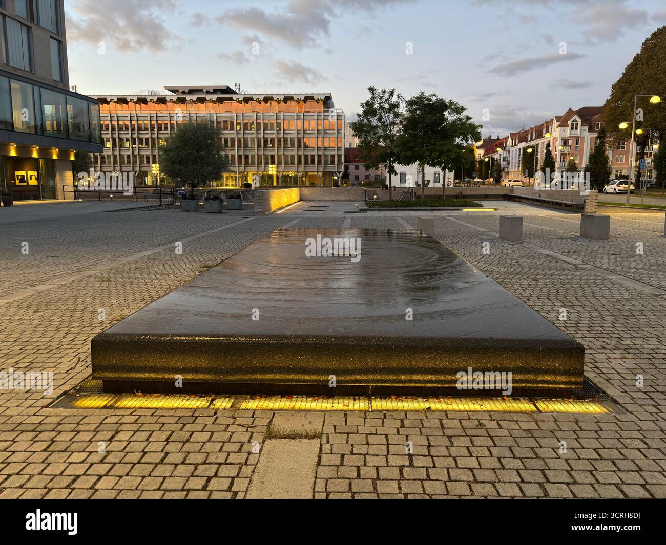 Sunset over iconic buildings in Landskrona Sweden with harbor structures and coastal skyline reflections. Stock Photo