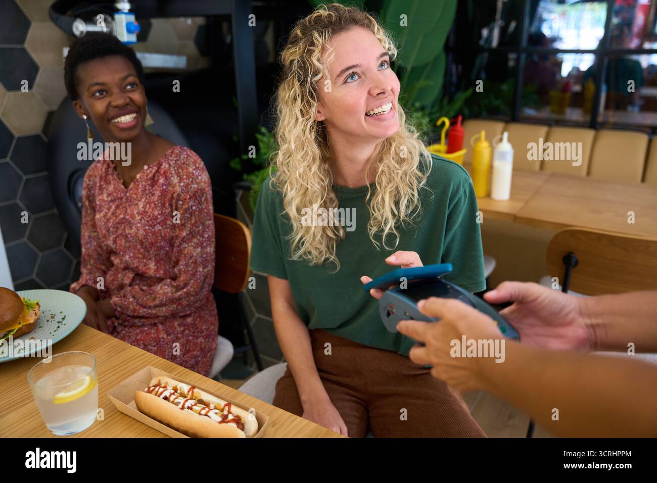 Woman paying for food with mobile phone Stock Photo