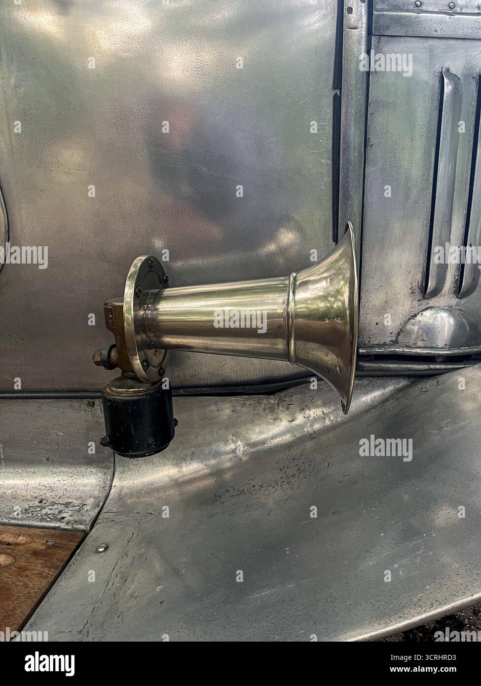 A key with keychains is inserted into the keyhole of a glass door overlooking an English garden - Smartphone Captured Stock Image