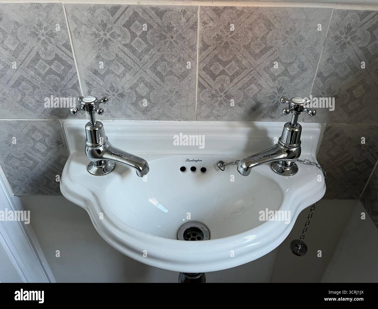 Sink with two separate cold and hot water taps in England. - Smartphone Captured Stock Image