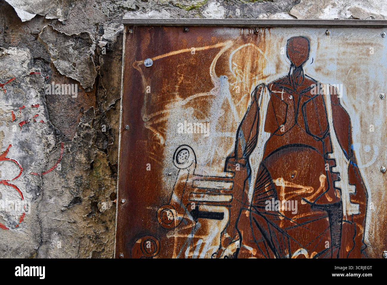 Street art on a rusty metal panel depicting a stylized figure standing next to old telephone handsets, unknown artist, Genoa, Liguria, Italy Stock Photo