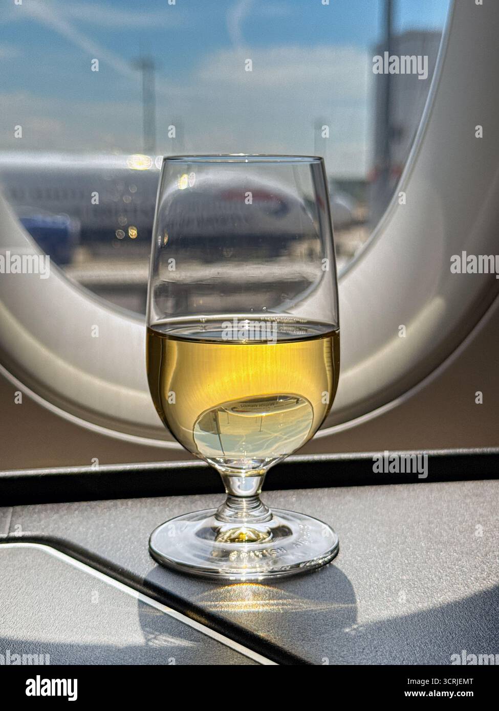 London, England, UK - 19 May 2025: Glass of champagne on the window shelf in the Club World business class cabin of a British Airways plane. No people - Smartphone Captured Stock Image