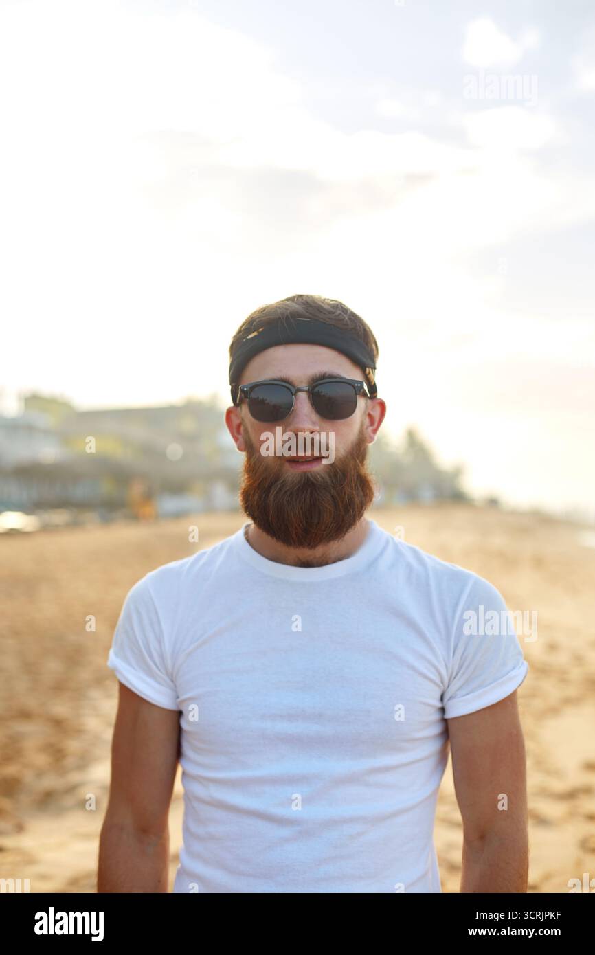 Portrait of handsome bearded man in shirt on the beach. Stock Photo