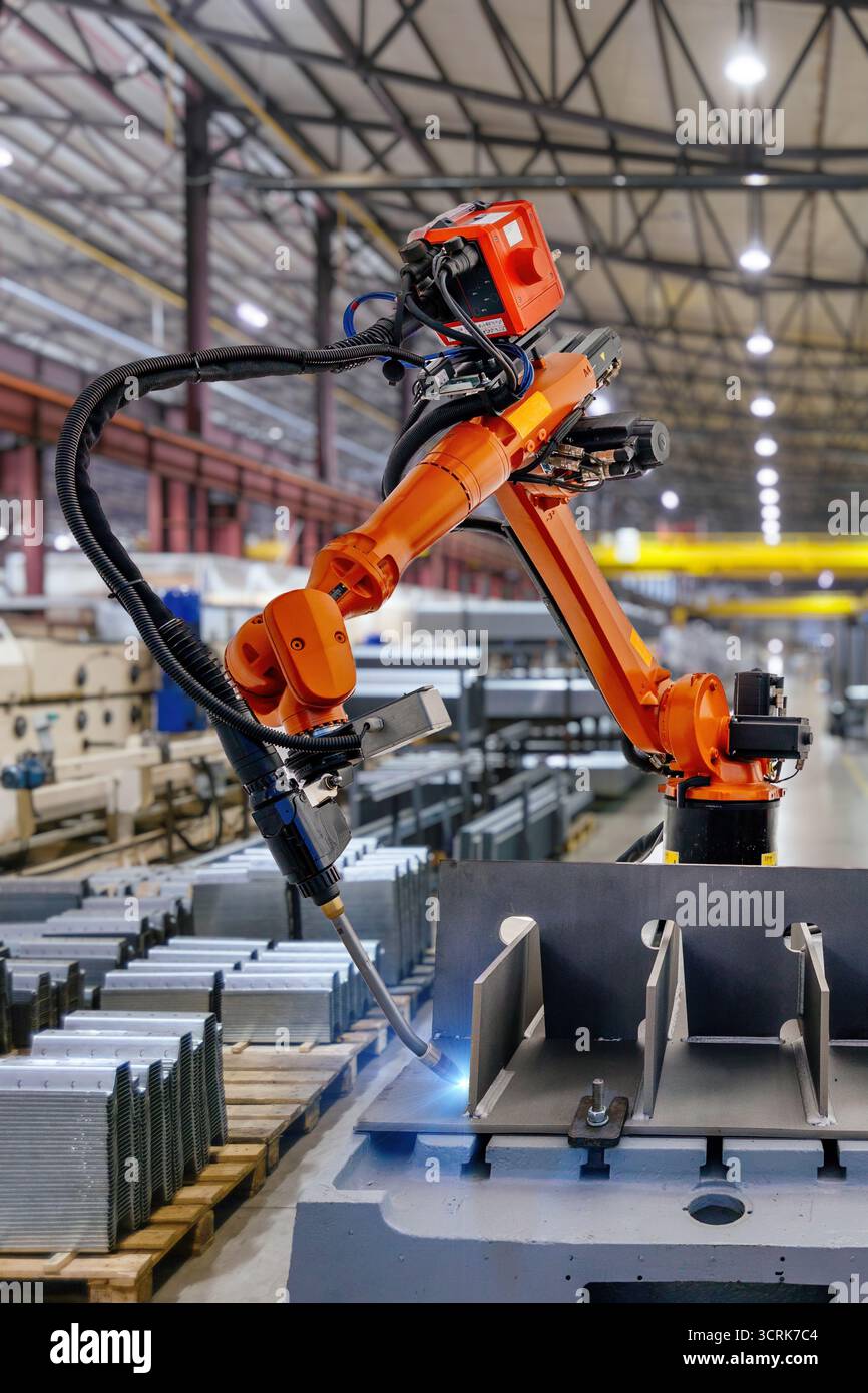 Industrial robot is welding metal part. Stock Photo
