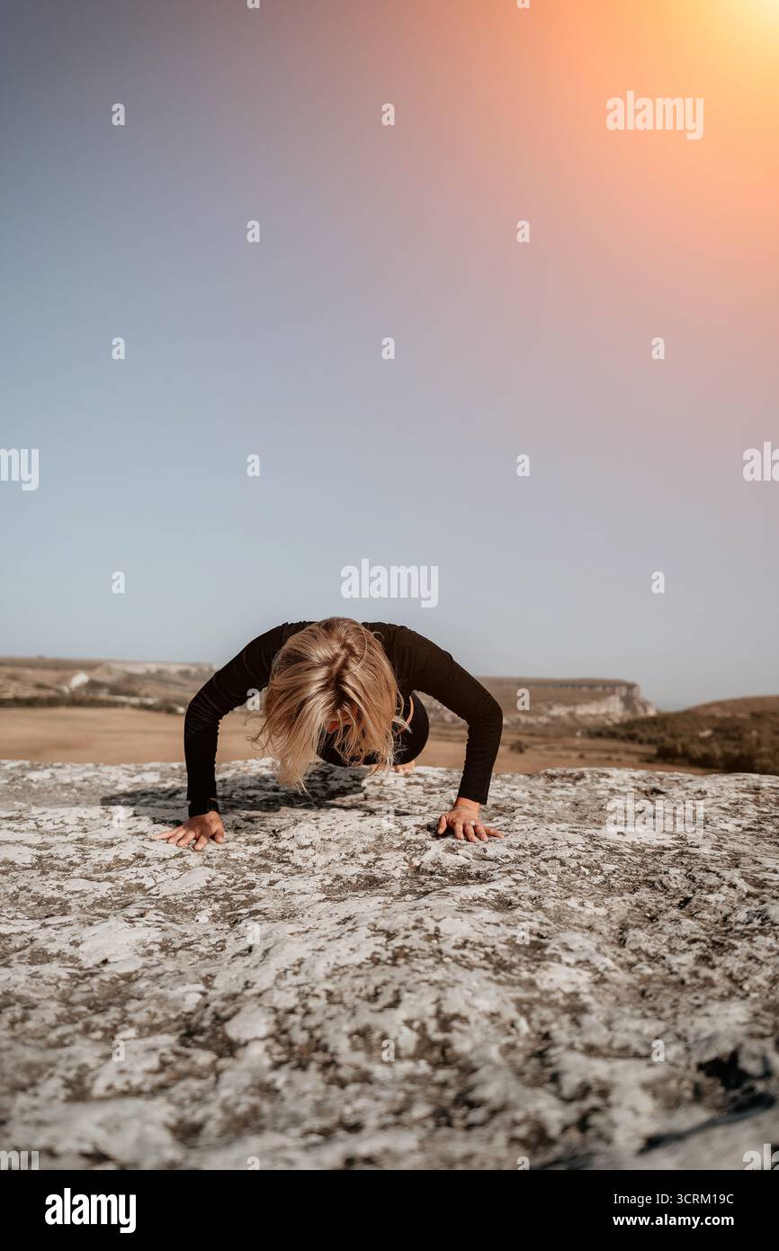 Woman Doing Push-Ups on a Rocky Cliff Stock Photo