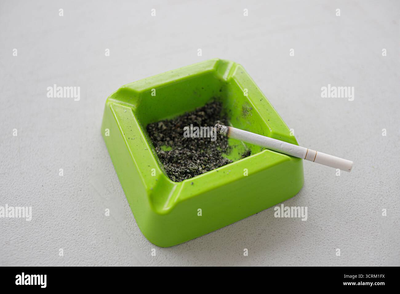 Lighting cigarette in ashtray isolated on white background Stock Photo