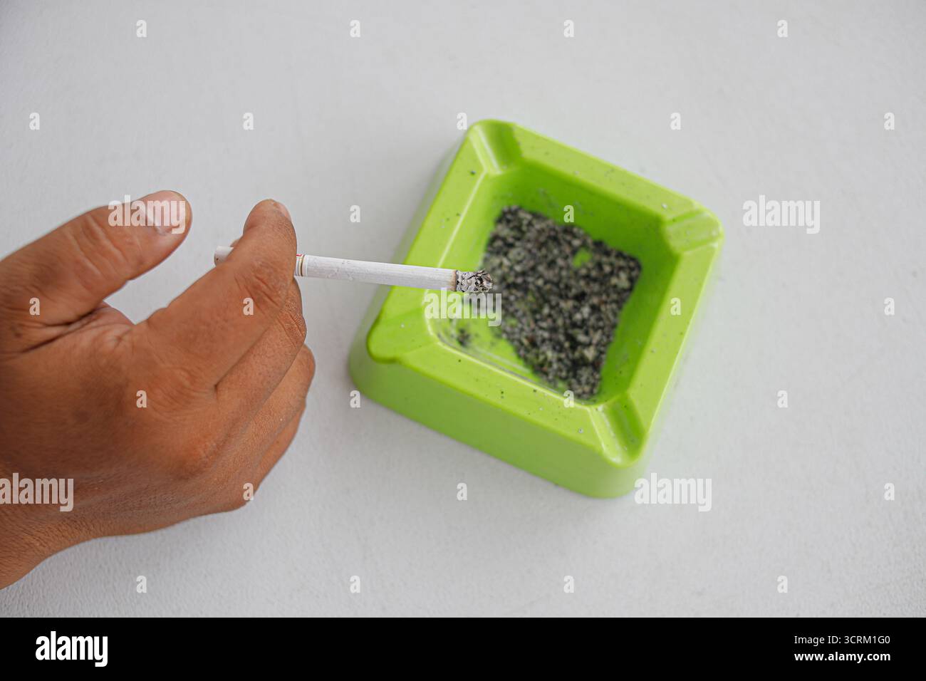 Lighting cigarette in ashtray isolated on white background Stock Photo