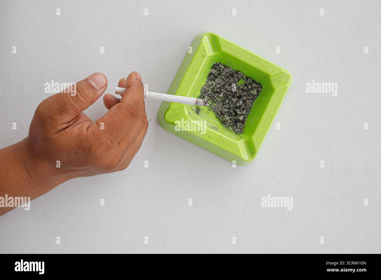 Lighting cigarette in ashtray isolated on white background Stock Photo