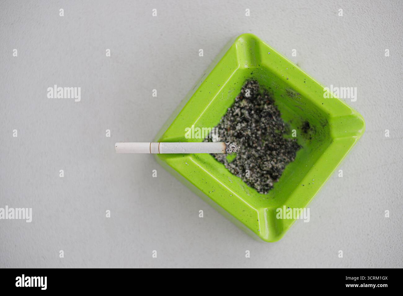 Lighting cigarette in ashtray isolated on white background Stock Photo