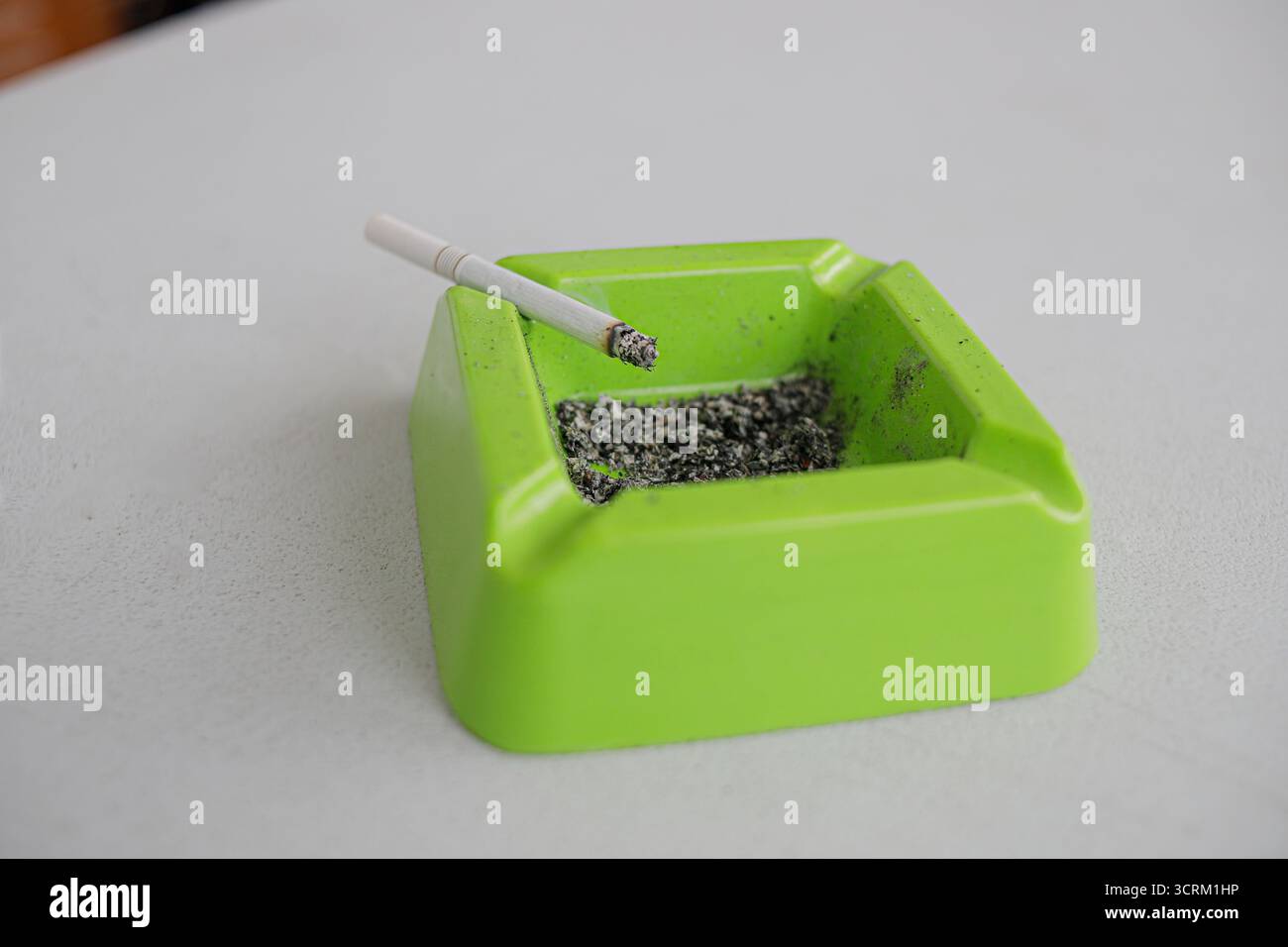 Lighting cigarette in ashtray isolated on white background Stock Photo