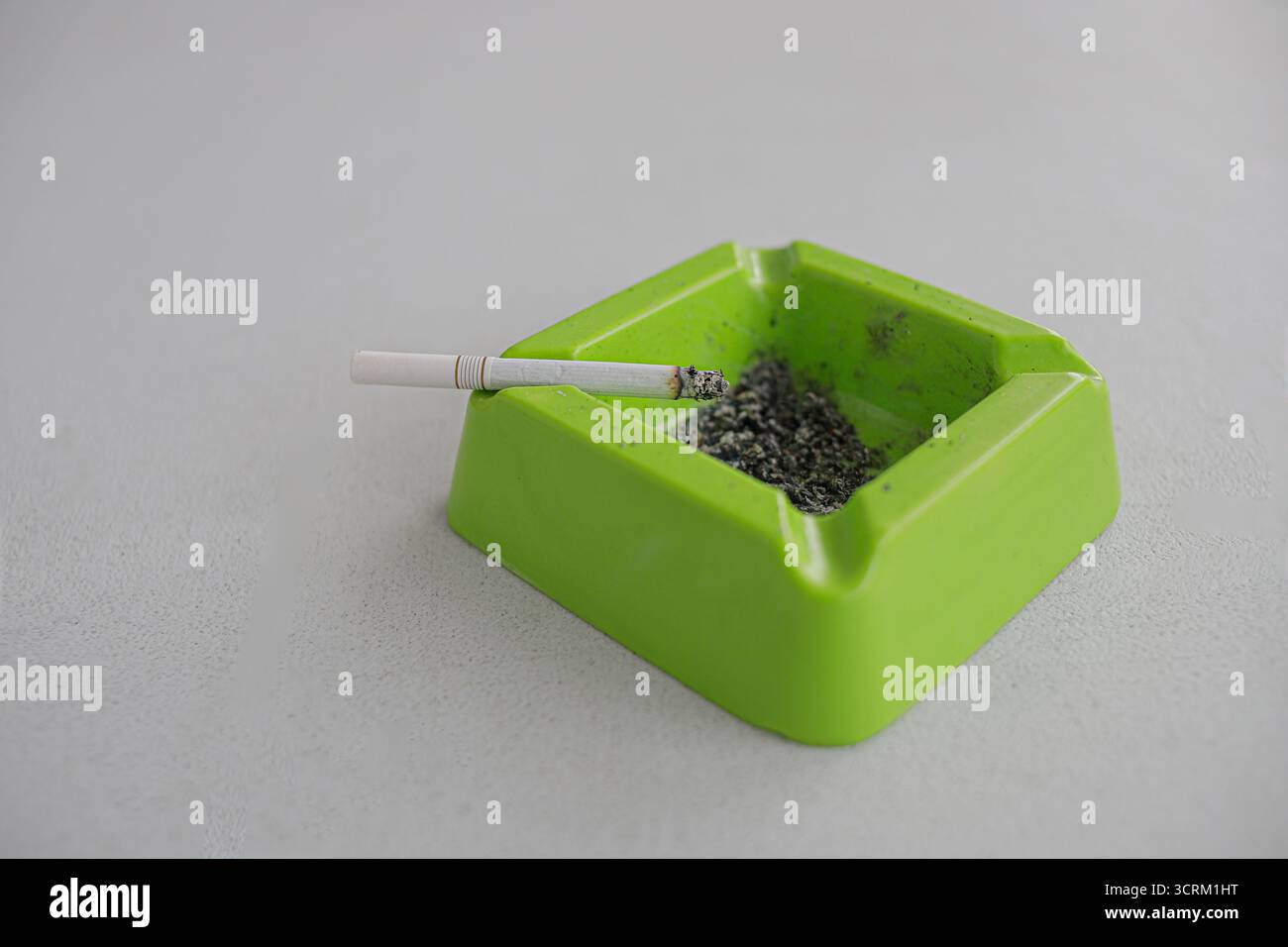 Lighting cigarette in ashtray isolated on white background Stock Photo