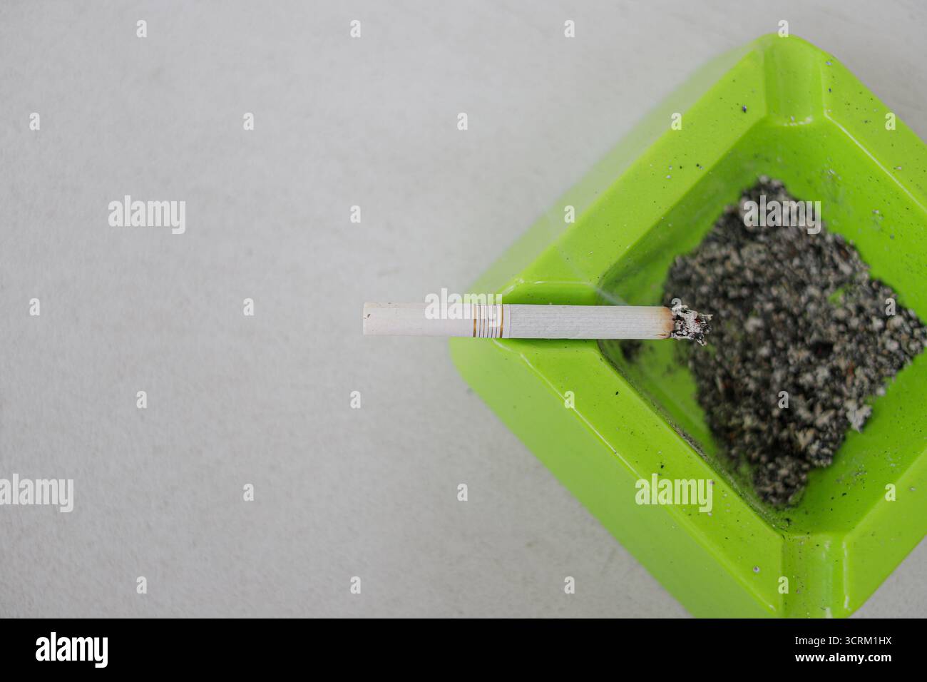 Lighting cigarette in ashtray isolated on white background Stock Photo