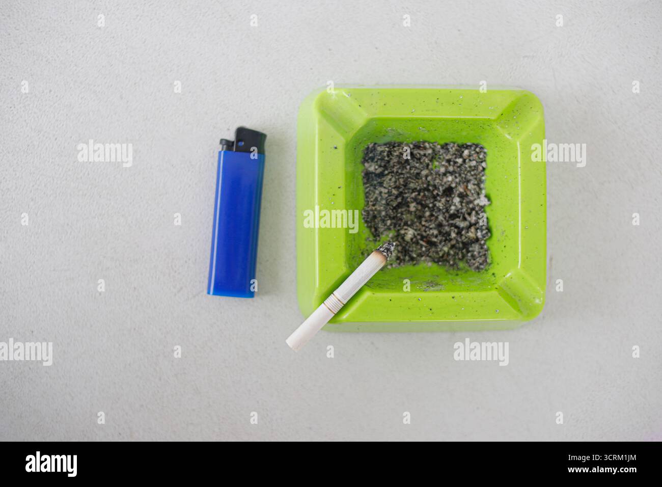 Lighting cigarette in ashtray isolated on white background Stock Photo