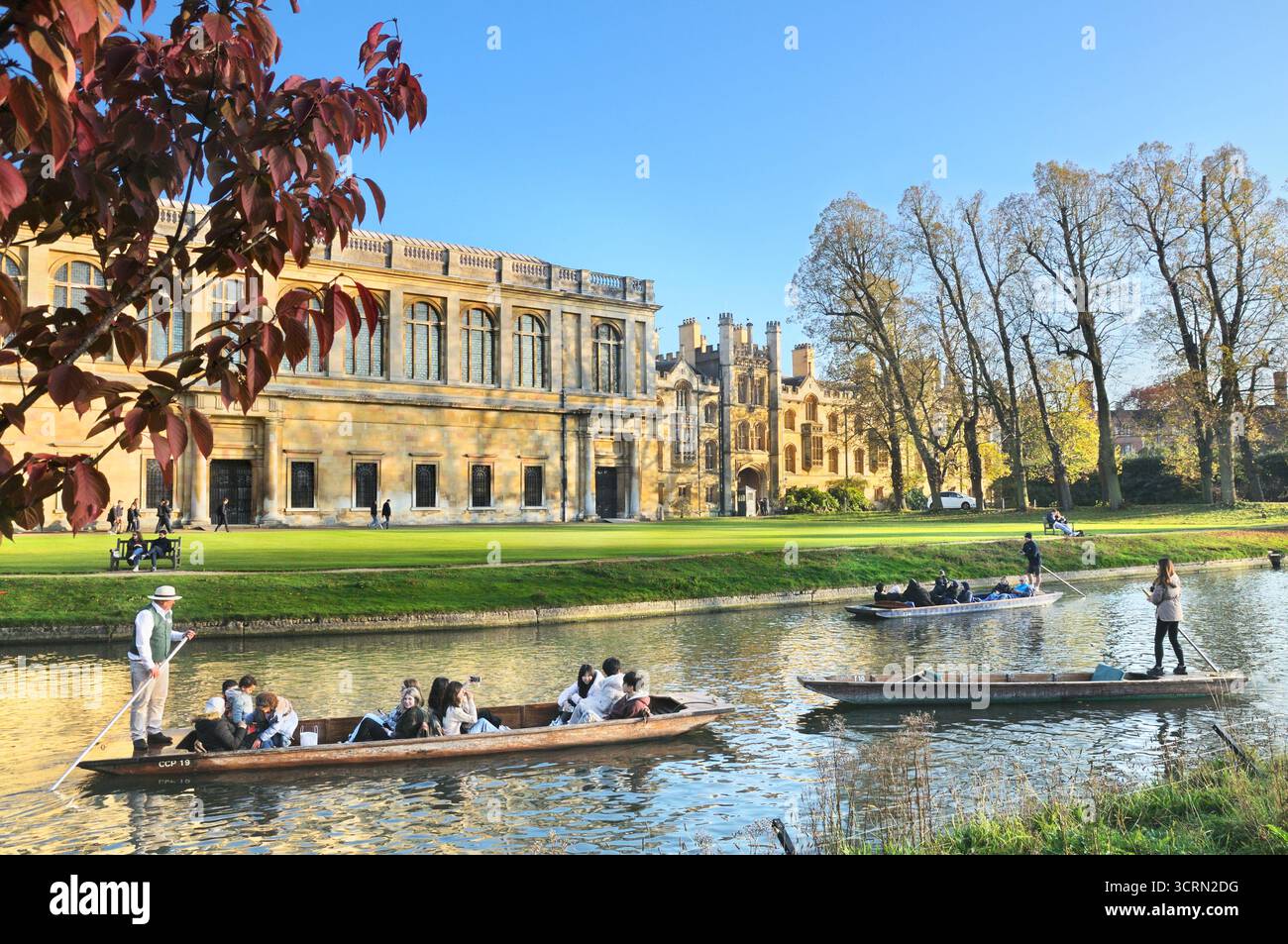 Punters steering tourists in wooden punt boats / punts on River Cam past Trinity College Wren Library, The Backs, University of Cambridge, England, UK Stock Photo