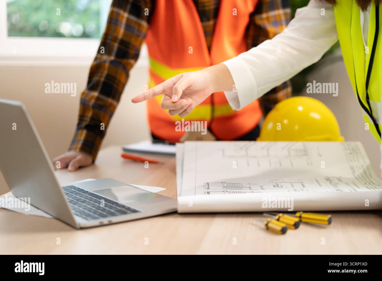 Engineers team use laptop and check the blueprint on site. Contractor and inspector inspection construction during project.civil Forman check quality Stock Photo
