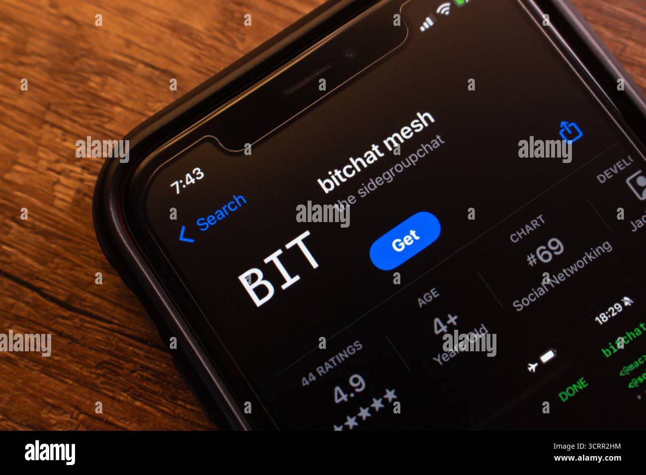 Closeup of BitChat Mesh app page on an iPhone screen, showing download button, rating, and app store listing details. Stock Photo