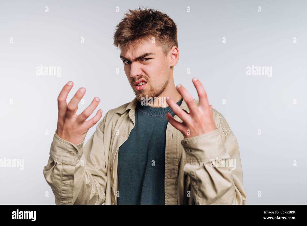 Young man expressing frustration with hands raised Stock Photo