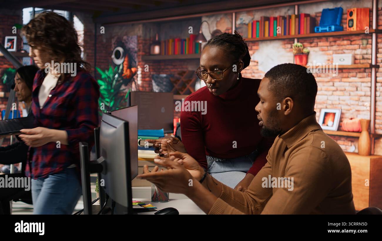 Teamworking programmers creating deep learning models analyzing data in artificial intelligence development agency. African american IT coworkers programming in AI startup office, camera A Stock Photo