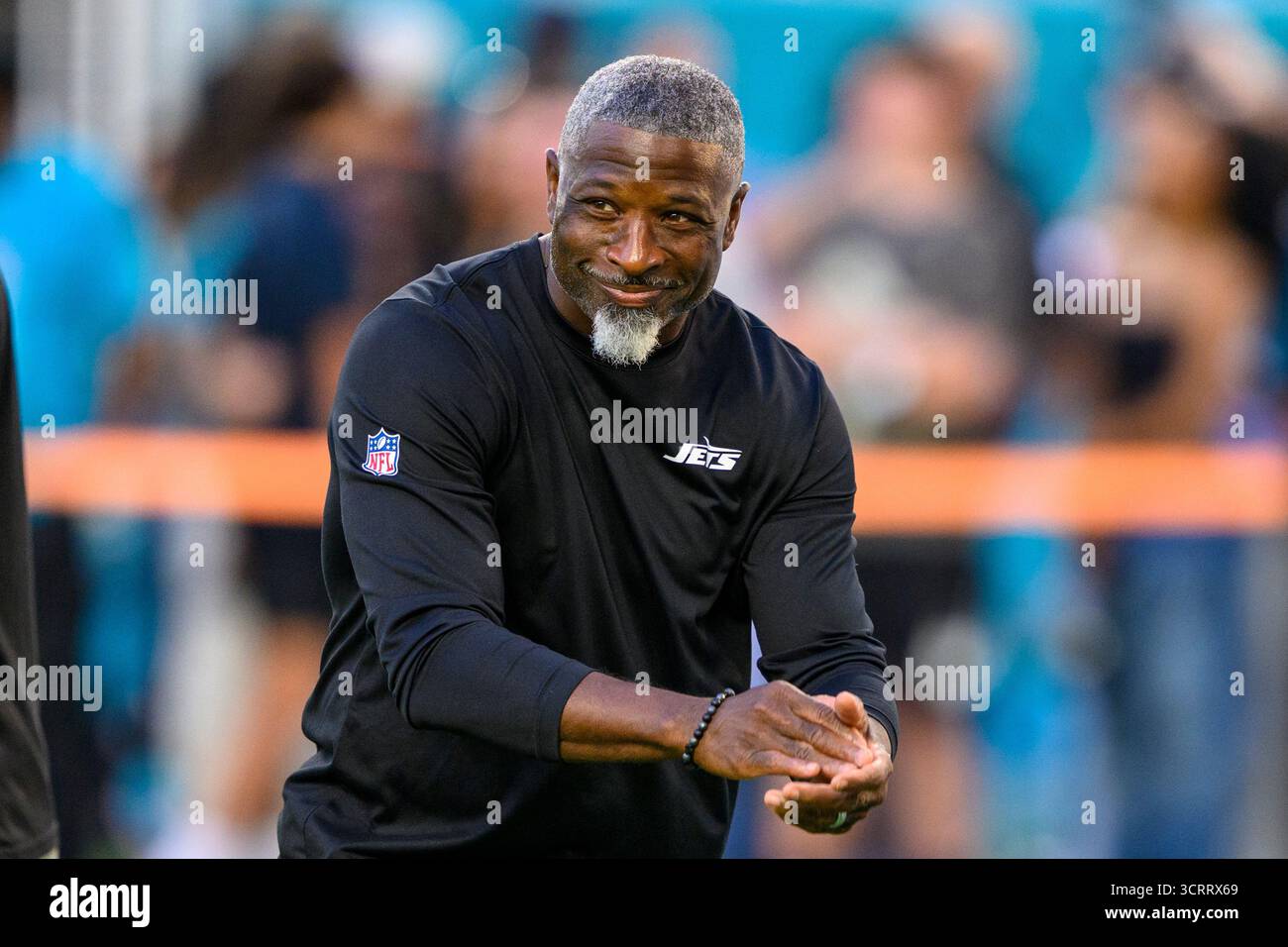 New York Jets head coach Aaron Glenn smiles on the field before an NFL ...