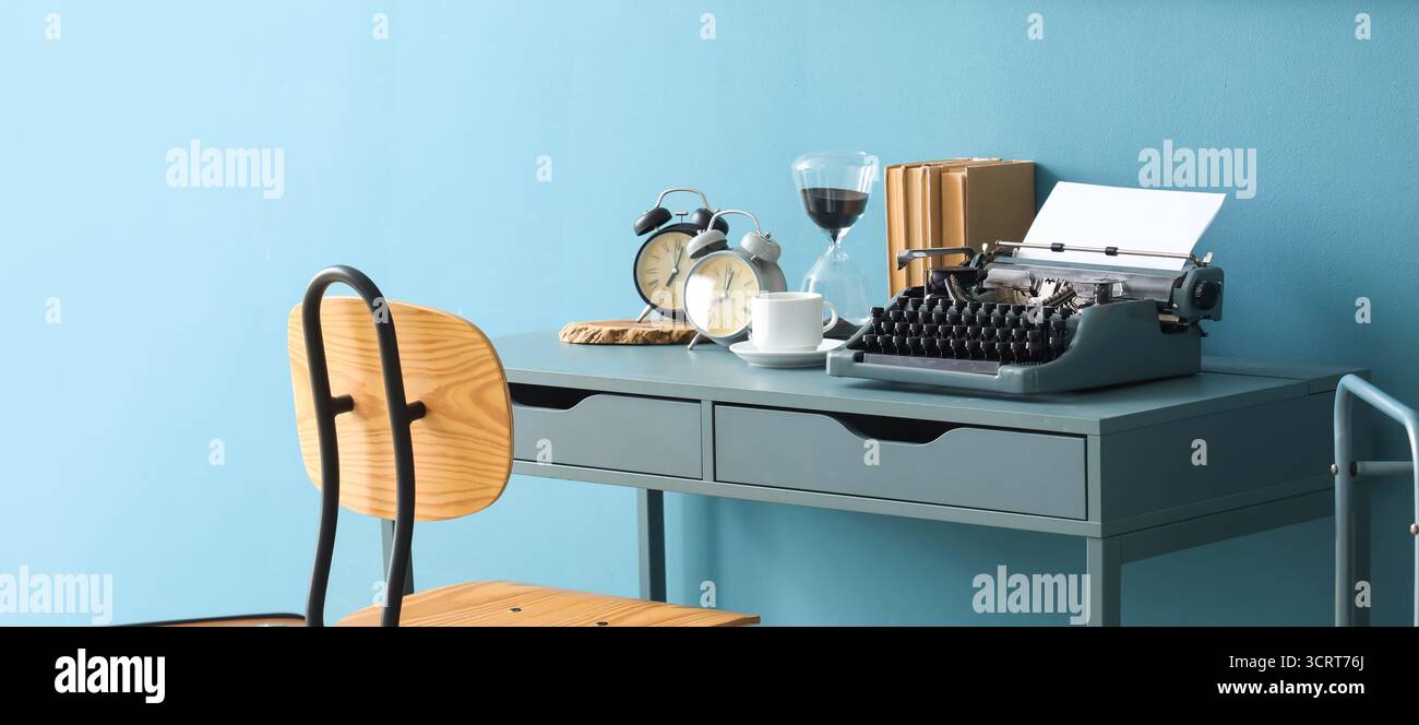 Vintage typewriter with clocks and books on table in office Stock Photo