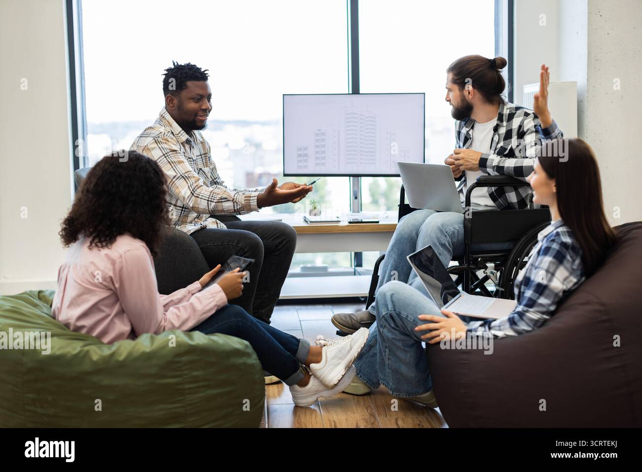 Diverse team collaborating on project in modern work environment Stock Photo